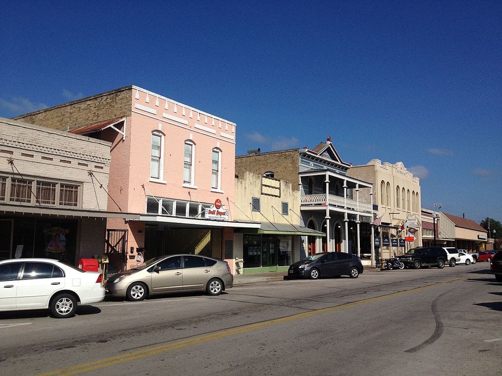 Historic downtown street with parked cars and buildings.