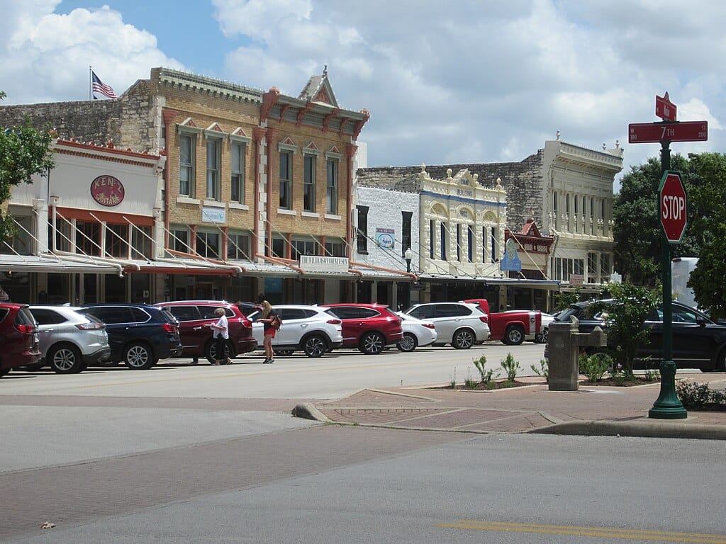 Historic downtown street with parked cars and shops.