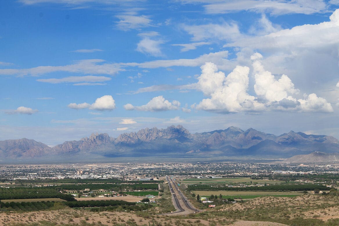 View of mountains and cityscape under blue sky.