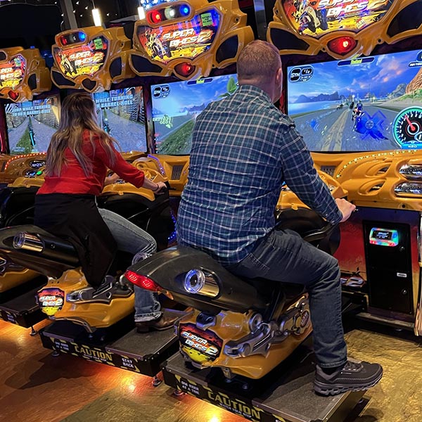 People racing motorcycles in an arcade game