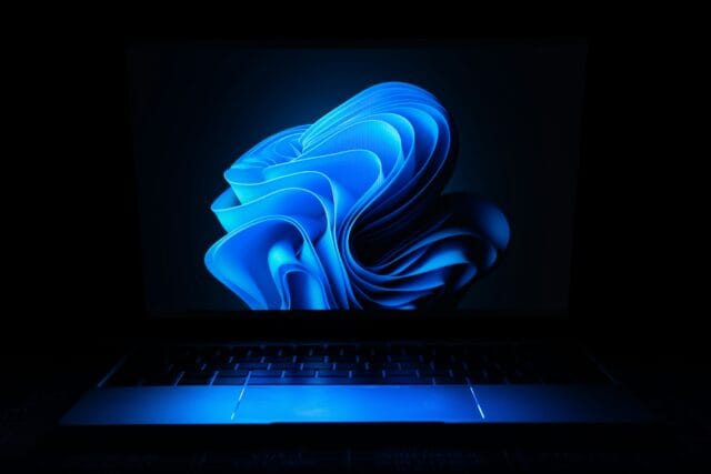 Laptop screen displaying abstract blue digital wallpaper