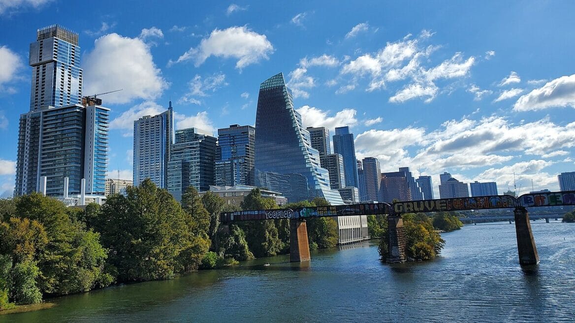 Downtown skyscrapers and river with graffiti bridge